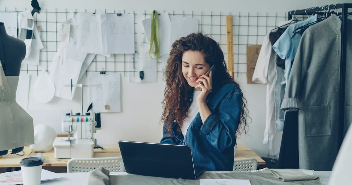 A business owner on the phone while working on a laptop
