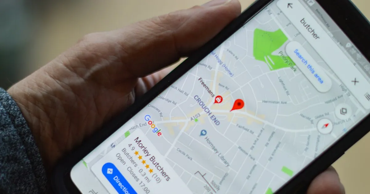 A hand holding a phone with Google Maps open on a local business listing. Photo by henry perks on Unsplash.